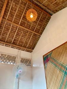 a room with a fan and a ceiling at Suba Beach Nipa Huts in Daanbantayan