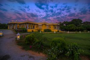 a large yellow building in a park at dusk at Dev Shree Deogarh in Devgarh