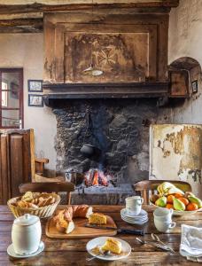 a table with food on it with a fireplace at Casa Rural Mas Garganta in La Pinya