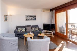 a living room with a couch and a tv at Edificio Tropicana in Tossa de Mar