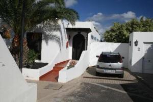 a car parked in front of a white house at Bungalow El Mar in Teguise