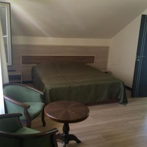 a bedroom with a bed and a table and chairs at Lucytour Hotel in Hermon