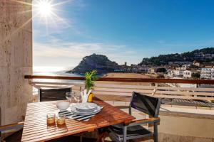 a table on a balcony with a view of the ocean at Edificio Tropicana in Tossa de Mar