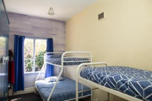 a bedroom with two beds and two windows at Pirates Backpackers in Fremantle