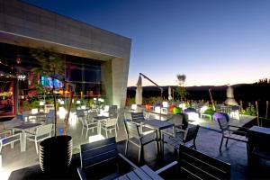 un patio avec des tables et des chaises en face d'un bâtiment dans l'établissement Hotel Casino Chaves, à Chaves