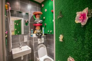 a bathroom with a toilet and a green wall at Absolute Hotel Paris République in Paris