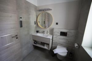 a bathroom with a white sink and a mirror at Villa Mangó in Balatongyörök +11 photos