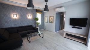 a living room with a couch and a flat screen tv at Villa Mangó in Balatongyörök