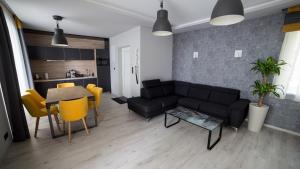 a living room with a black couch and a table at Villa Mangó in Balatongyörök