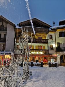 a snow covered tree in front of a building at Les Airelles in La Clusaz