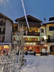 a snow covered tree in front of a building at Hôtel Les Airelles in La Clusaz