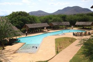 a large swimming pool with people in the water at Voi Wildlife Lodge in Voi