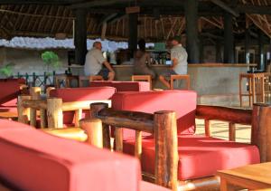 grupa czerwonych krzeseł siedzących w restauracji w obiekcie Voi Wildlife Lodge w mieście Voi