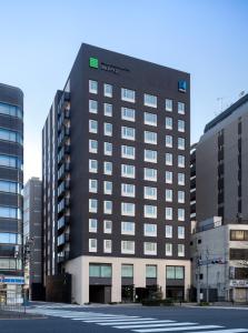 um edifício preto alto numa cidade com edifícios em Ginza Capital Hotel Moegi em Tóquio