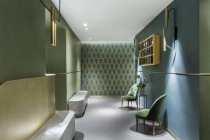 a room with green walls and two green chairs at Condominio Monti Boutique Hotel in Rome