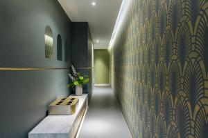 a hallway with a bench and a wall with a wallpaper at Condominio Monti Boutique Hotel in Rome