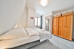 カルパチにあるPanorama Gór w Karpaczuのベッドルーム1室(ベッド1台付)、木製キャビネットが備わります。