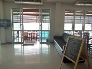 a living room with a couch and a sign on the floor at Amatara Hotel in Phimai