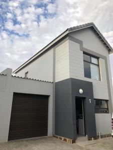 a white and gray house with a garage at Dolphin Leap 7 in Walvis Bay