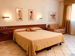 1 dormitorio con 1 cama y 1 silla en Hotel Delfina, en Signa