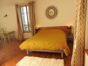 a bedroom with a yellow bed and a mirror at Domaine de Laverchère in Pommiers-en-Forez