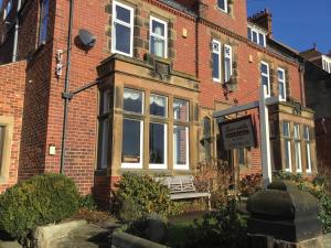 a brick house with a sign in front of it at Lee-Side B&B in Robin Hood's Bay +21 photos