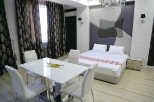 a room with a dining table and a bed at Promenade Boutique Apartment in Bishkek