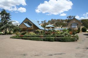 a house with a flower garden in front of it at Willows Motel in Goulburn