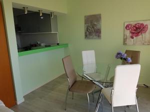 uma sala de jantar com uma mesa de vidro e cadeiras em Tulipa View Apartament no Funchal
