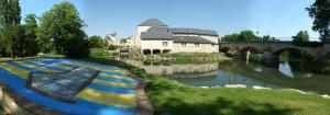 a rendering of a building next to a river with a bridge at Ma Location Saisonnière in Chasseneuil-du-Poitou
