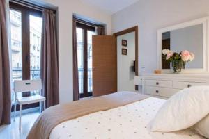 a bedroom with a bed with a dresser and a mirror at Apartment Villegas in Seville
