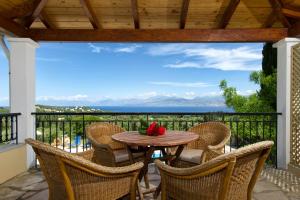 a table and chairs on a balcony with a view at Villa Bacchus Kassiopi Corfu in Kassiopi