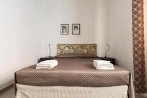 una camera da letto con un letto e due asciugamani di Versomare by BarbarHouse a Porto Cesareo