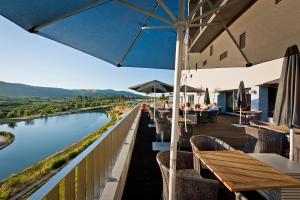 a restaurant with tables and chairs and a river at Hotel Casino Chaves in Chaves