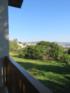 a balcony with a view of a field of trees at Lagoa Seca Hotel Rural in São Lourenço