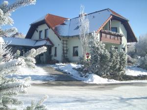 a house in the snow with snow covered trees at Ferienwohnungen Moritz in Riechheim