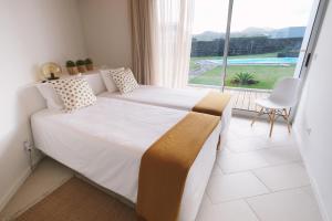 a bedroom with a bed and a large window at Sao Vicente Lodge - Atlantic Retreat in São Vicente Ferreira