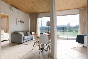 a living room with a couch and a table at Sao Vicente Lodge - Atlantic Retreat in São Vicente Ferreira
