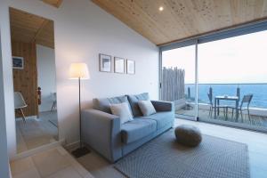 a living room with a couch and a view of the ocean at Sao Vicente Lodge - Atlantic Retreat in São Vicente Ferreira