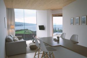 a living room with a table and chairs and a large window at Sao Vicente Lodge - Atlantic Retreat in São Vicente Ferreira