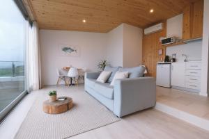a living room with a couch and a table at Sao Vicente Lodge - Atlantic Retreat in São Vicente Ferreira