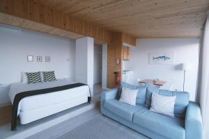 a bedroom with a bed and a couch at Sao Vicente Lodge - Atlantic Retreat in São Vicente Ferreira