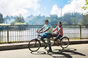 un hombre y una mujer en bicicleta en The Carlton Kodaikanal, en Kodaikanal