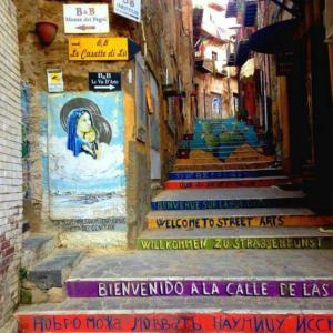 Un callejón con escaleras con una pintura. en B&B Al Dammuso, en Agrigento