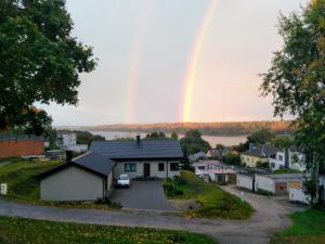 a rainbow in the sky over a house at Central place with lake view in Šiauliai