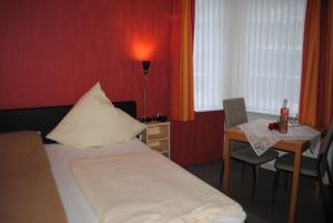 a hotel room with a bed and a table with a tableablish at Hotel Garni Nolting in Esens