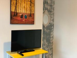 a flat screen tv sitting on top of a yellow table at Gordon House - Kettering in Kettering
