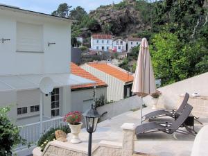 a patio with two chairs and an umbrella on a roof at Apartamentos Playa Monte Pindo - Morada Druida in O Pindo