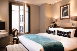 a hotel room with two beds and a desk at Hotel & Spa La Belle Juliette in Paris