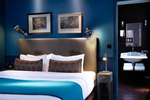 a blue bedroom with a bed and a sink at Hotel & Spa La Belle Juliette in Paris
